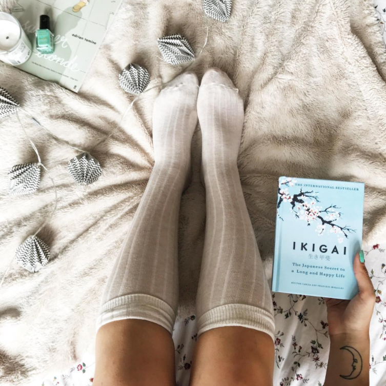 girls legs on bed and book
