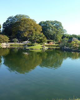 Big pond with little islands and with the water reflecting trees in Korakuen Garden, Okayama