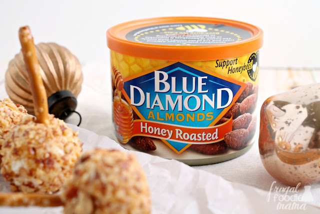 These Mini Honey Roasted Almond Cheese Balls are a creamy mixture of mozzarella, Parmesan, & cream cheese that are rolled in sweet & crunchy honey roasted almonds and served on a pretzel stick.