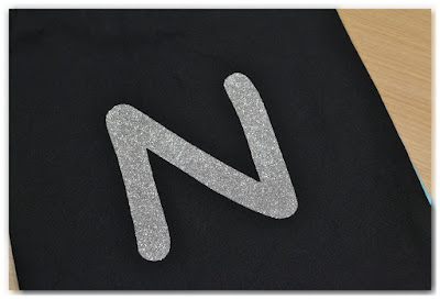 lettre N en flex à paillettes argentées thermocollée sur tissu noir