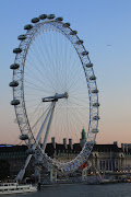 Situated along the banks of the River Thames, The London Eye is one of the . (london eye at twilight on river thames and the london country hall in the background)