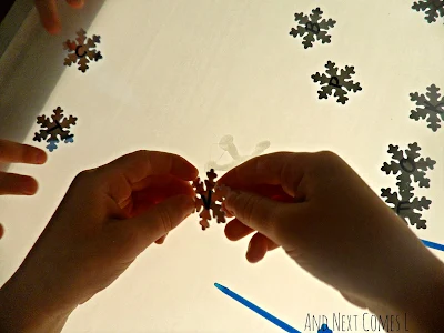 Close up of fine motor skills during snowflake light table play from And Next Comes L