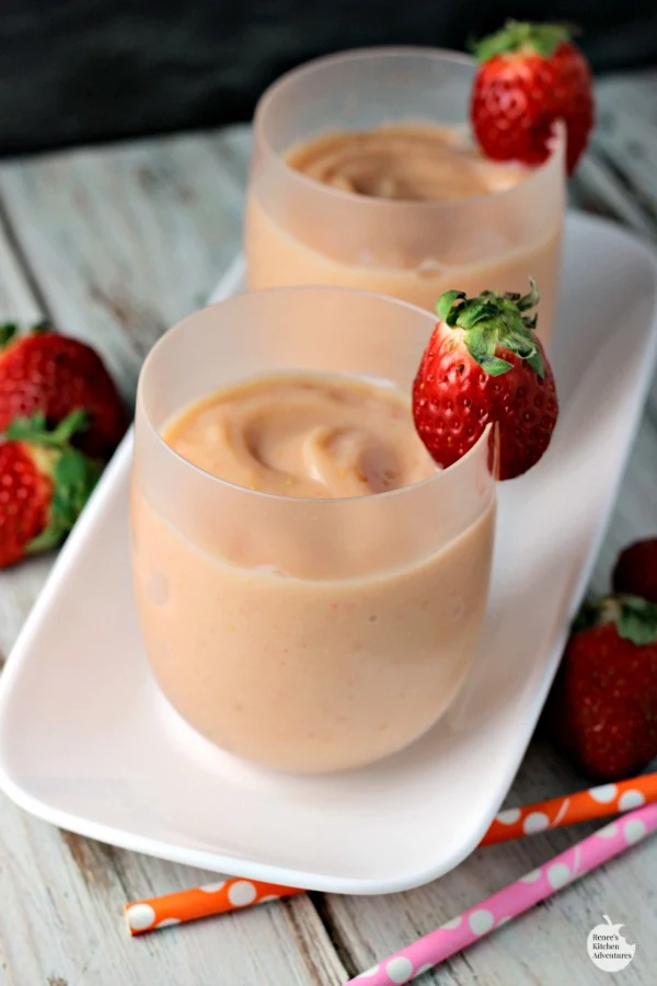 Easy Strawberry Mango Smoothies | by Renee's Kitchen Adventures glasses full of smoothie on a white platter with pink and orange polka dot straws all around as decoration