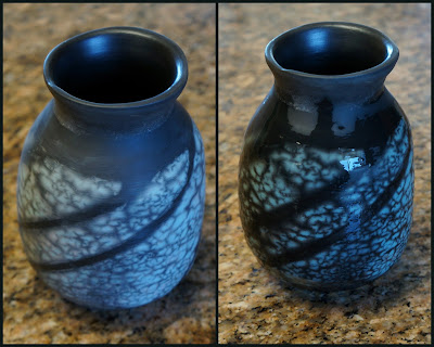 Naked raku pottery - a turquoise vase with black stripe pattern - showing effects of water on the color.
