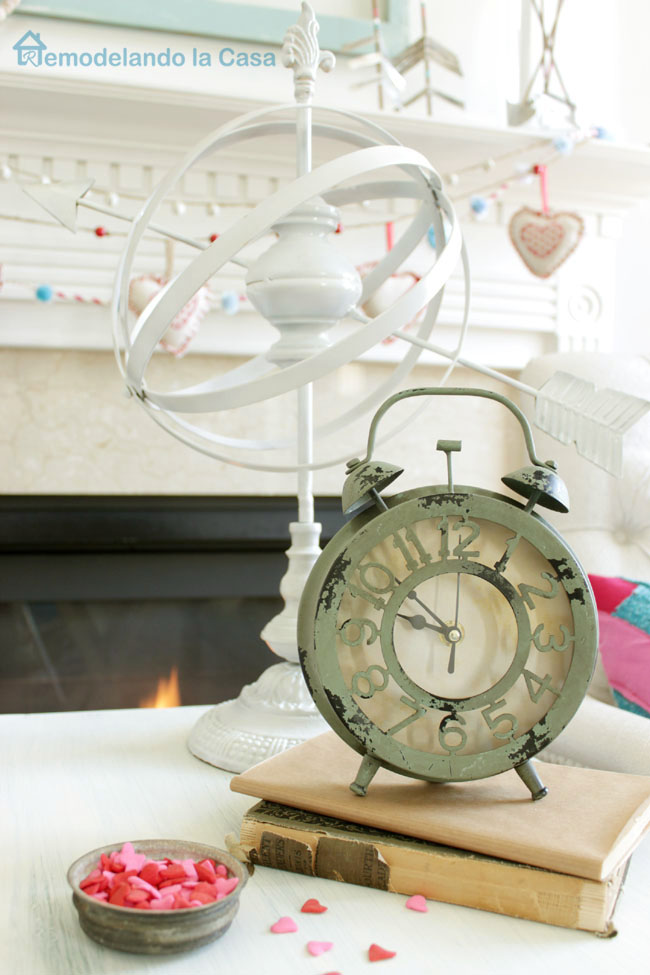 rustic clock and armillary sphere adorning a Valentines mantel