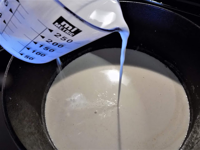 A picture of half and half being poured into a pot