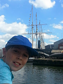 View from The Matthew Boy leaning over boat side with ships in the background