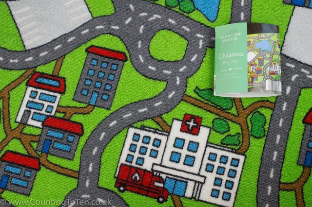A close up of a play mat with buildings and roads