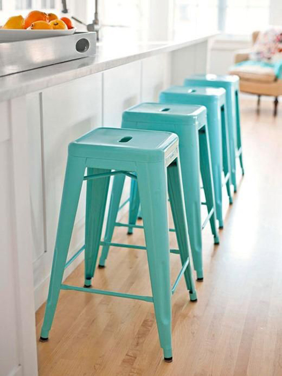 In line turquoise tolix counter stools add a fresh note in an otherwise neutral kitchen.