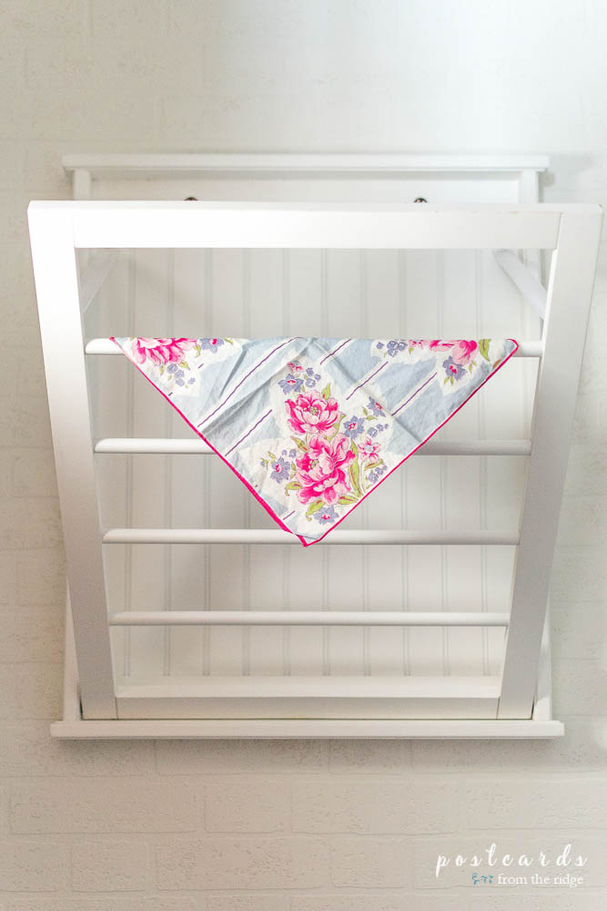 This low budget laundry room makeover is darling. Love the drying rack and vintage hankie!