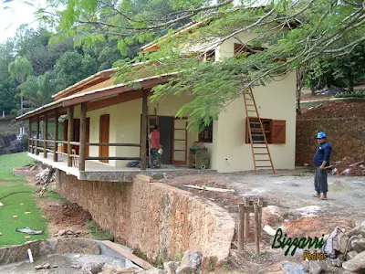 Base com pedras na construção de churrasqueira com muro de pedra moledo.