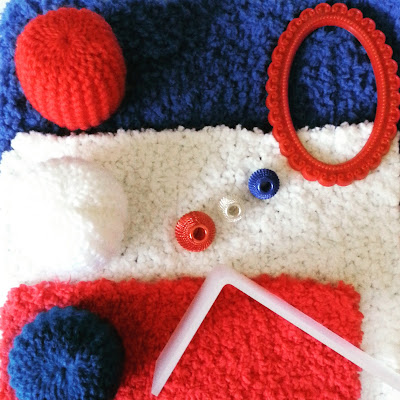 One-twelfth scale modern miniature fluffy rugs, knitted pouffes and accessories in the colours red, white and blue.