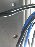 Camera shot of the under-side of the car console, showing two screws.