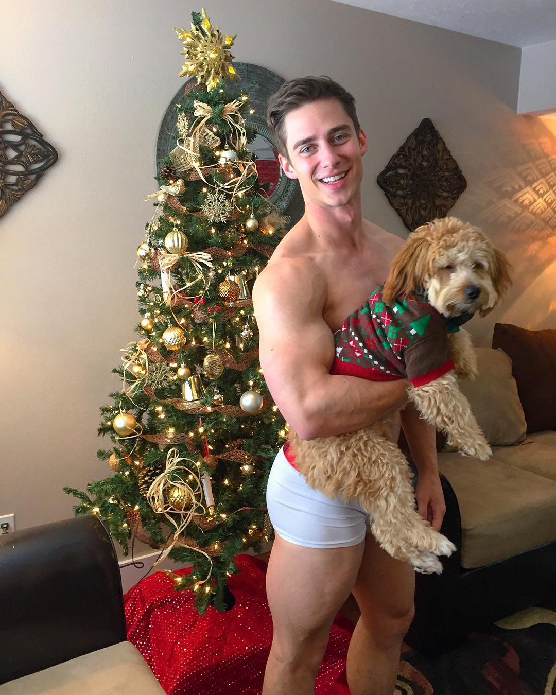 shirtless-dude-smiling-cute-dog-christmas-tree