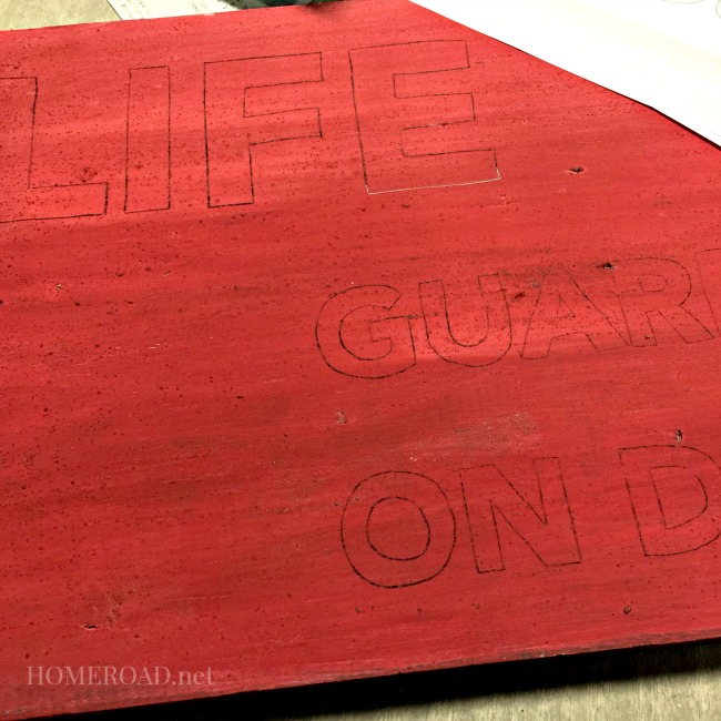 Red sign with outlined letters in pencil