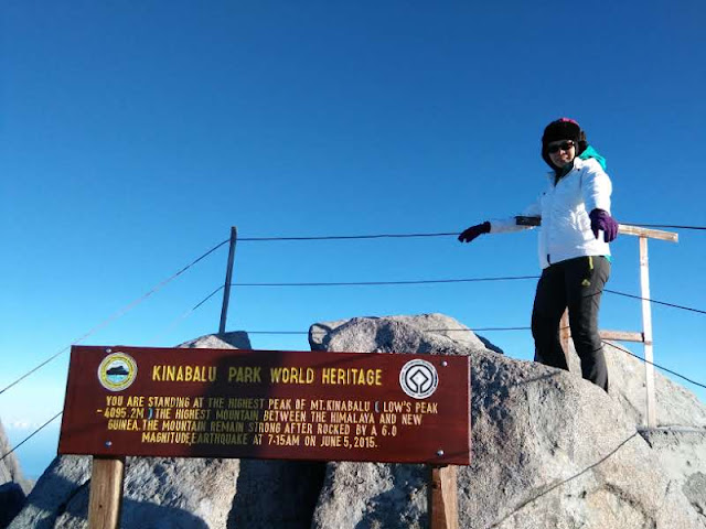 This is a photo about mount kinabalu itenary blog post and showing a climber on top of mount Kinabalu