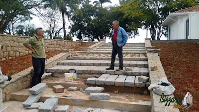 Bizzarri visitando a obra e orientando a construção da escada de pedra com pedra folheta com a mureta de pedra com paralelepípedo rachado nesse tom de cor de pedra cinza escuro em sede da Fazenda em Atibaia-SP.