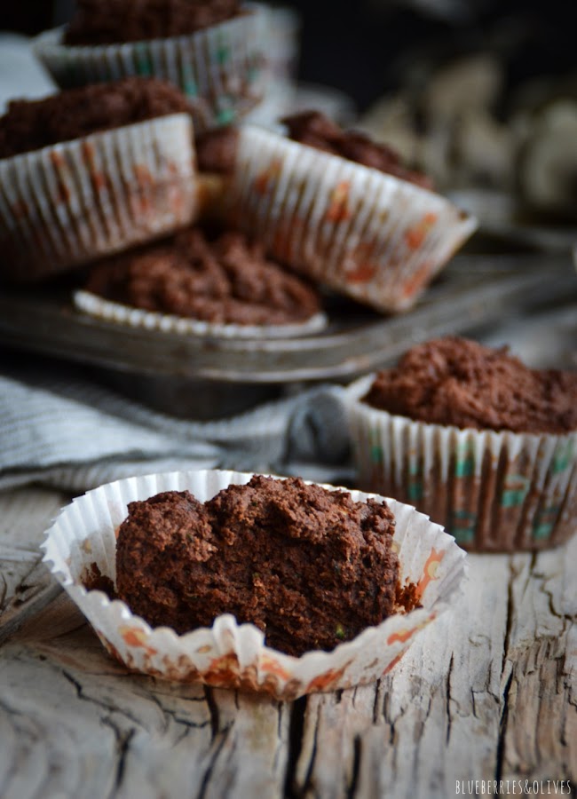 Bandeja metálica retro de muffins, paño cocina de lino gris,plato y taza de cerámica para café, fondo oscuro, luz de vela, ramas secas eucalipto