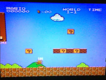 [Image: A somewhat blurry photo of an LCD TV showing Super Mario Bros.]