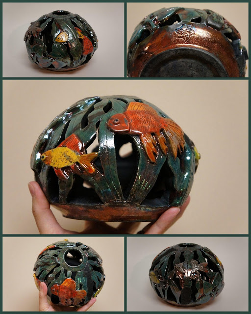 Unique and beautiful raku pottery vessel with carved fish bowl design.