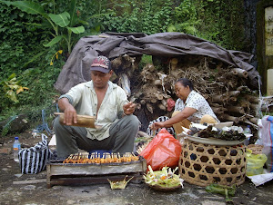 SATE SELLERS FAN THE FLAMES ROADSIDE IN UBUD