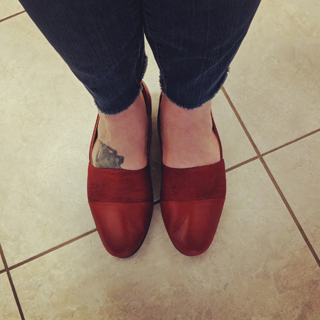 image of my feet on a tile floor, wearing red loafers