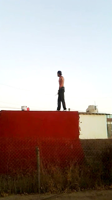 Joven con arma blanca sobre el techo de una vivienda