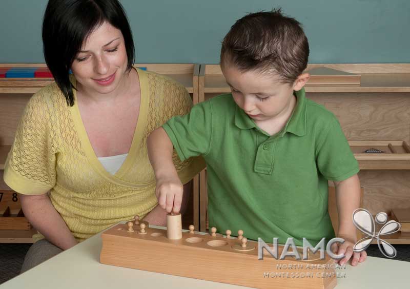 NAMC circle of inclusion montessori materials built in control of error. Boy and teacher with cylinder blocks