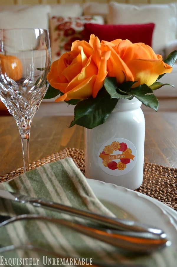 Decorated mason jar with orange flowers on holiday table setting