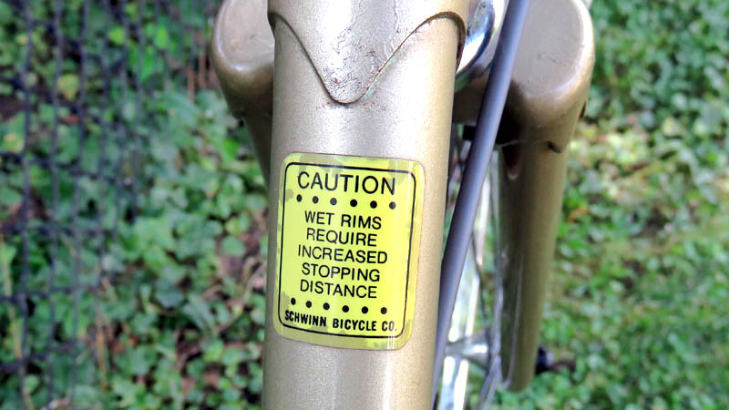 Yellow sticker on bicycle saying wet rims increase stopping distance