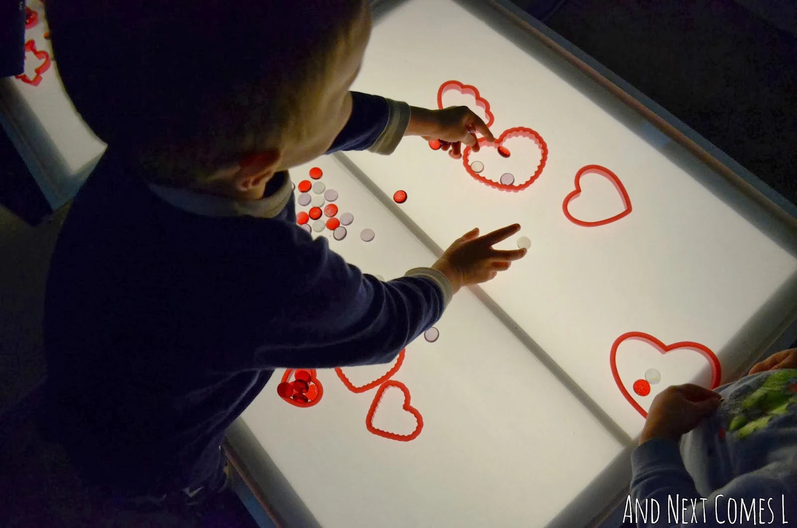 Playing with hearts and glass stones on the light table for Valentine's Day from And Next Comes L