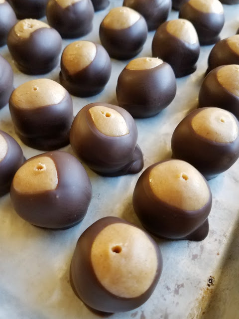 Turn that classic combination of peanut butter and chocolate into a great no-bake candy. These buckeyes look like the nut, but taste much better! freshly dipped buckeye candies with their toothpick holes showing
