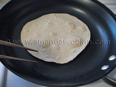 A photo of a low fat homemade flour tortilla being cooked in a skillet.