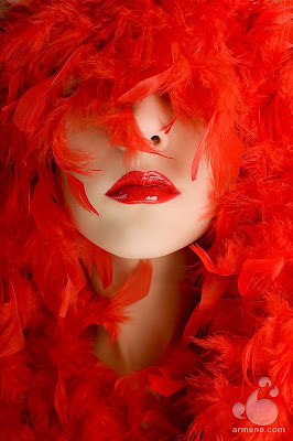 Fotografía mujer labios rojos y plumas rojas
