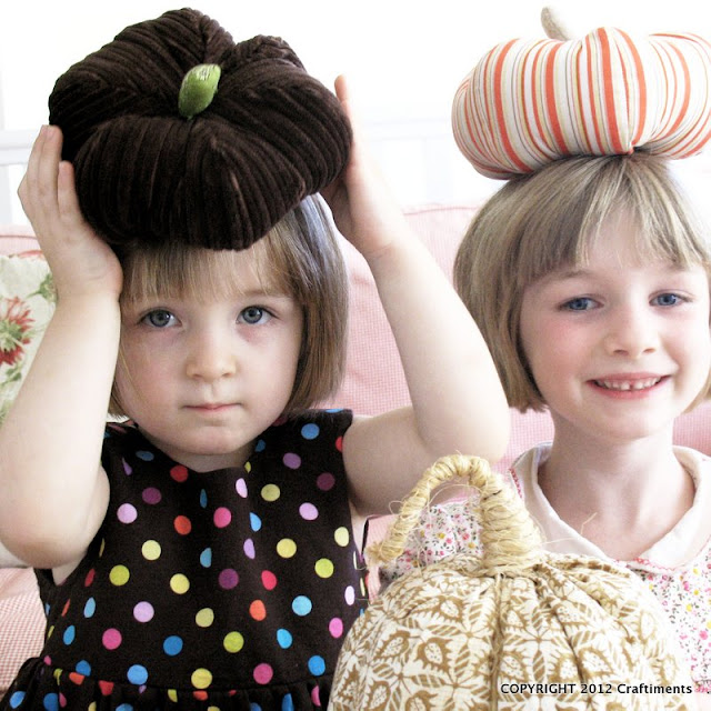 Kids balancing fabric pumpkins on their heads