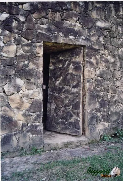 Detalhe da parede de pedra moledo com a porta de pedra moledo.