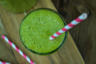 A Beginners Guide to Juicing -Green mango smoothie A Beginners Guide to Juicing - Green mango smoothie from above with stripey paper straw on wooden board