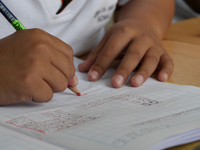 Kind schreibt in ein Matheheft
