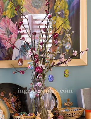 Hand-painted eggs hanging from a cherry blossom in a vase
