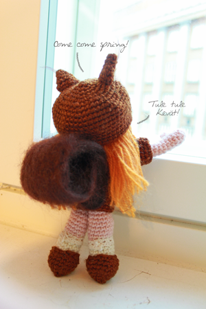 Amigurumi squirrel girl looking out through the window