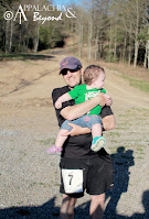 Tim holding baby bug outside at a trail race venue.