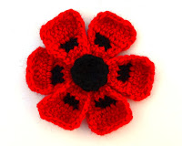 Crocheted Oriental Poppy: black centre, six red petals, the centre of each petal has a black spot created using an intarsia method.