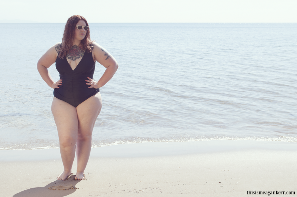 fille ronde et tatouée en maillot de bain sur une plage.