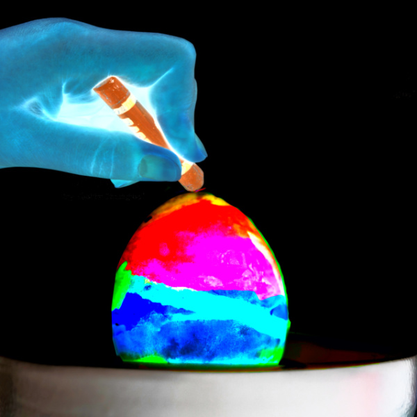 Decorate Easter eggs that glow using this melted crayon art technique.  My kids were in awe as the glowing colors swirled in this egg decorating activity! #glowingeastereggs #gloweastereggs #crayonart #crayonartmelted #crayoneggdecorating #crayoneggs #crayoneggdye #meltedcrayonart #eastereggdecorating #eastereggs #eastercrafts #growingajeweledrose