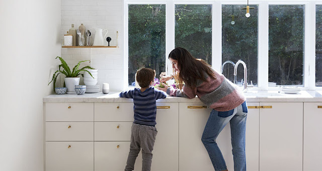 Eine Frau steht mit einem Kind in einer Küche