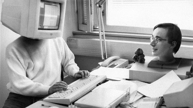 A photograph of Linus Torvalds in 1994, seated in front of a personal computer; his head has swapped places with the monitor.