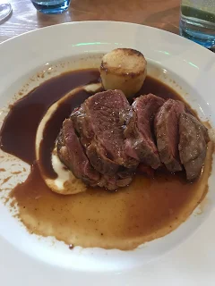 beef fillet on gravy bed with potato tower 