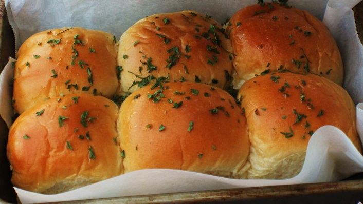 this is a recipe for homemade sweet potato rolls they are baked and in a pan brushed with butter