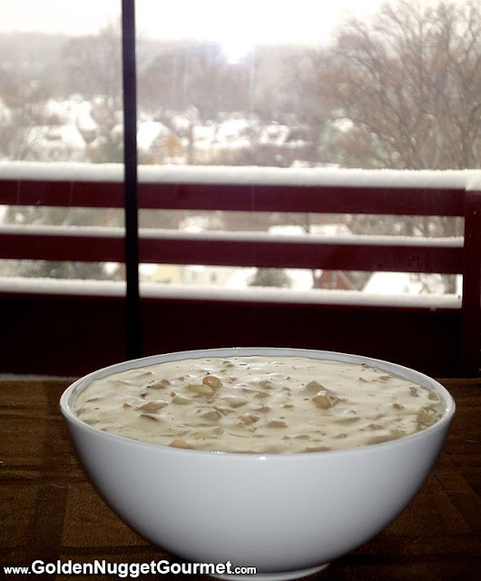 Bowl of clam chowder in front of snowy window
