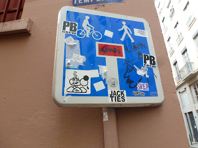Verkehrsschild mit Stickern und Tags unter anderem mit The London Police, in Lyon (Frankreich)
